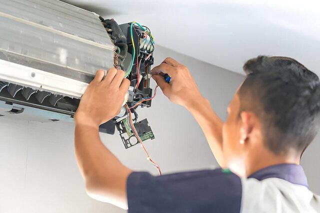 Técnico trabajando en un equipo de aire acondicionado